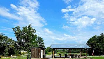 A park with a covered pavilion and a small wooden structure.