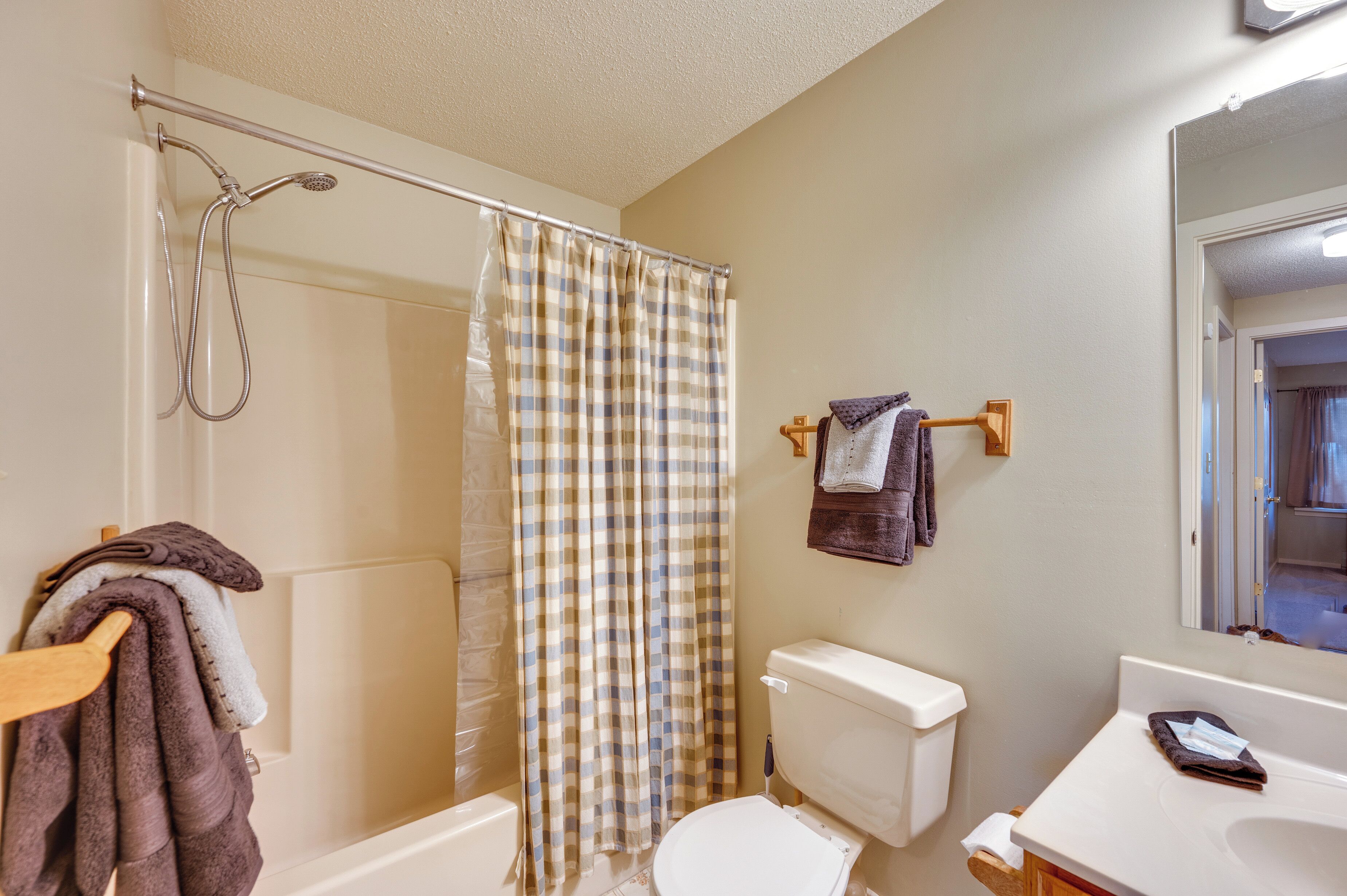 Une salle de bain avec douche, toilettes et lavabo.