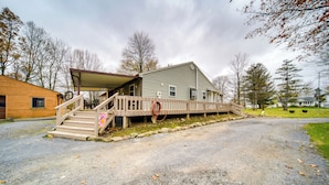 A two-story house with a covered porch and a wooden deck. - North Jackson Vacation Rental w/ Wraparound Deck! (North Jackson)
