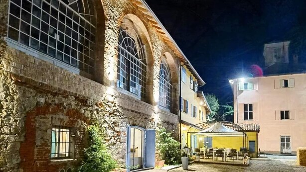 A historic building with large arched windows and a courtyard.