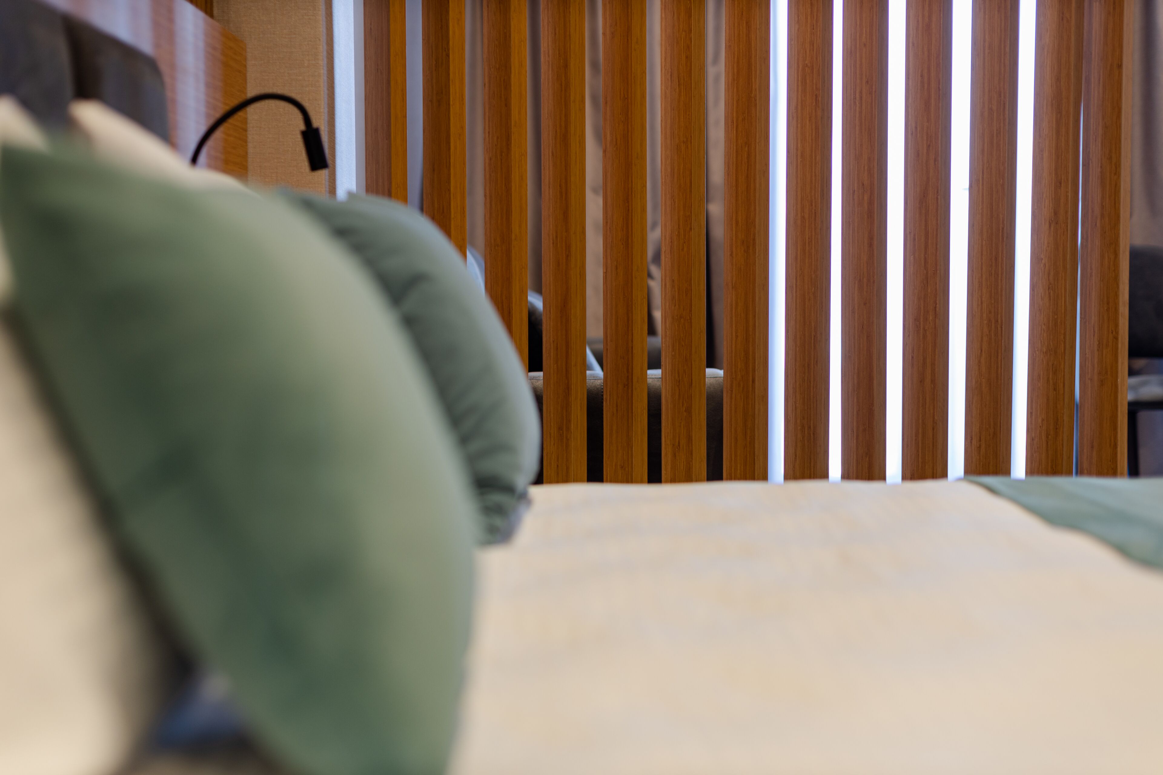 A bed with a wooden headboard and a green pillow.
