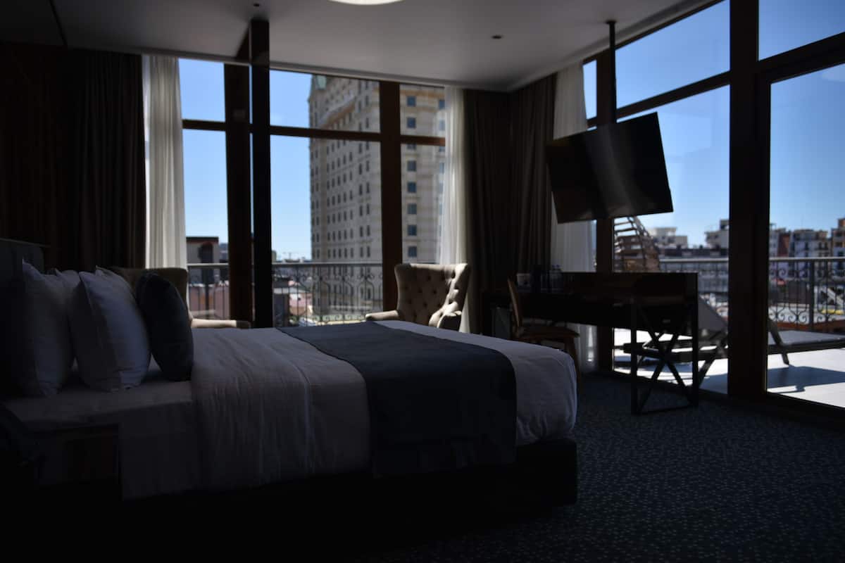 Una habitación de hotel con una cama grande, un escritorio y un televisor.