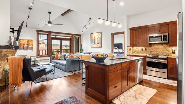 A spacious living room with a large island, a dining area, and a kitchen with modern appliances. - Luxury Resort Penthouse at Peak 9 Base/on Main St. (Breckenridge)