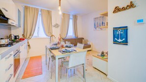 Un espace de vie compact comprenant une kitchenette, un coin repas et un canapé.