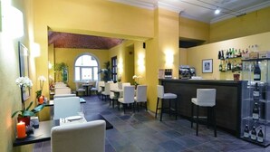 Un restaurante con paredes amarillas, un arco de ladrillo y una zona de bar con botellas.