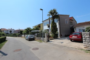A residential street with houses, a parked car, and a clear sky.