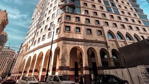 A multi-story hotel with a classic architectural design, featuring arched windows and a central entrance. - Diyafa Al Mukhtara Hotel (Madinah)