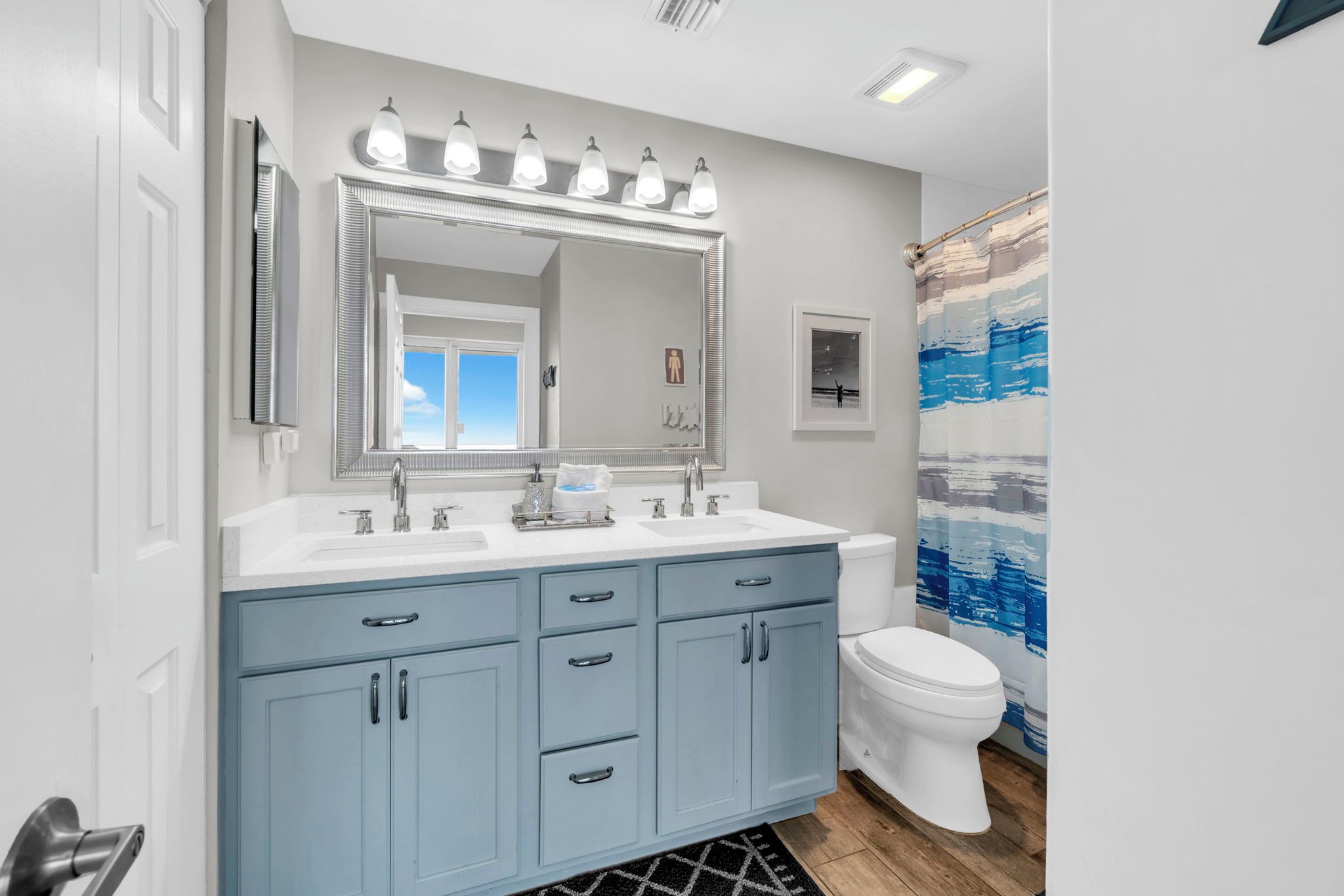 A bathroom with a white sink, double vanity, and a toilet.