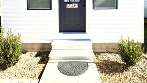 A white building with a black door, numbered 3, and two windows with blinds. - Bass Cabin: Arcade, Inflatables, Fishing & More! (Guntersville)