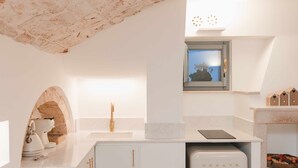 Une cuisine moderne dotée d’un plan de travail en marbre, d’un four encastré et d’une fenêtre offrant une vue agréable.
