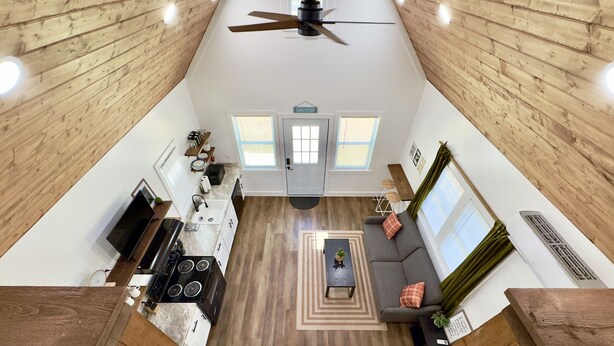 A spacious living area with a kitchen, dining table, and a sofa.