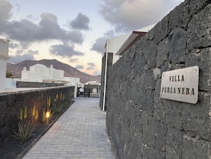 A pathway leading to Villa Perla Nera, with a stone wall and a signboard. - Escape to Paradise:Villa Perla Nera – Your Oasis of Comfort and Serenity!
(Playa Blanca)