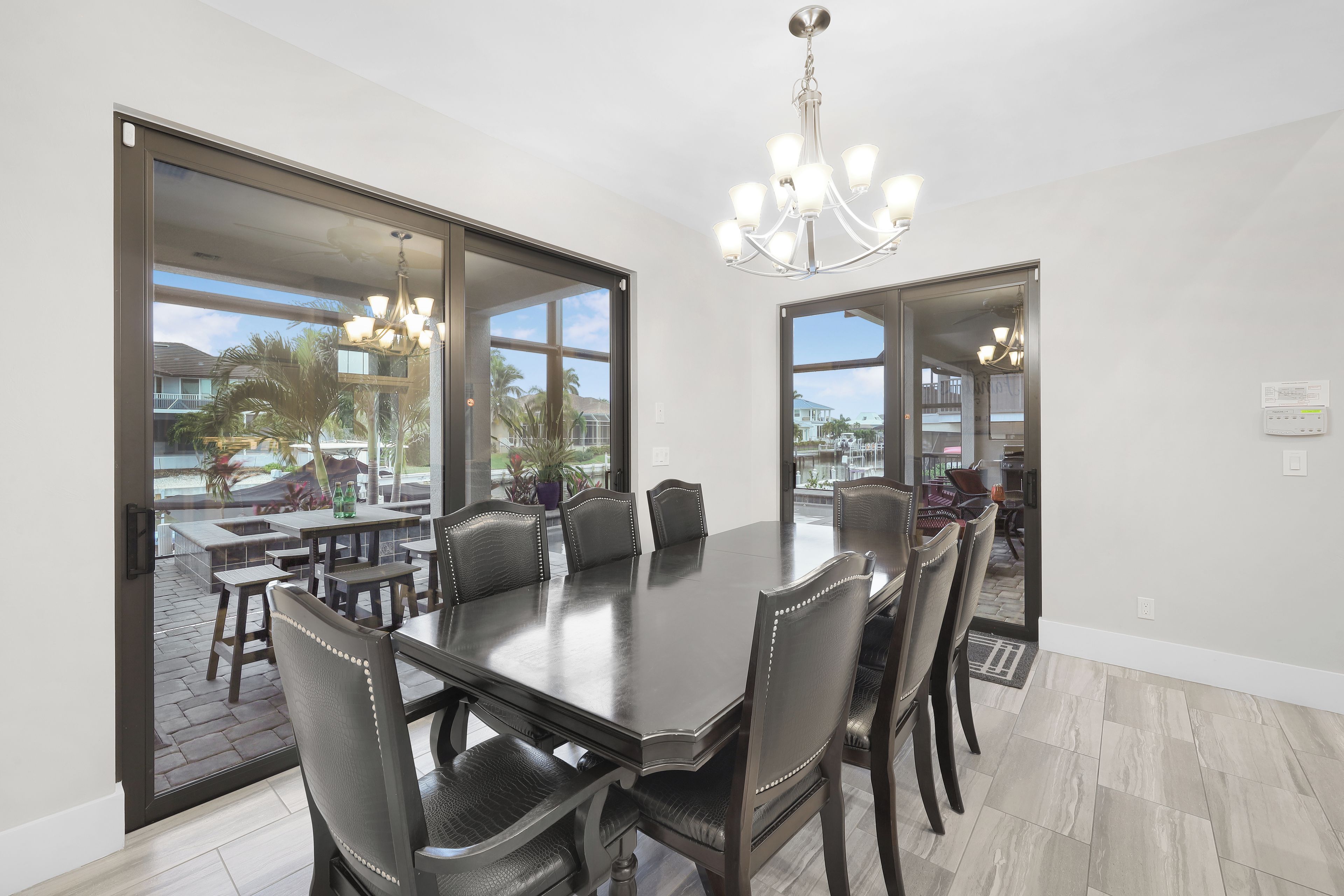 A dining area with a large table, chairs, and a chandelier.