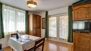 Un comedor con una mesa, sillas, una lámpara de techo y armarios de madera.
