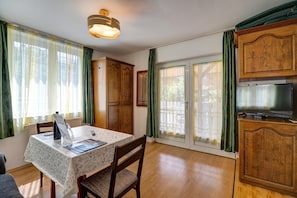 Un comedor con una mesa, sillas, una lámpara de techo y armarios de madera.