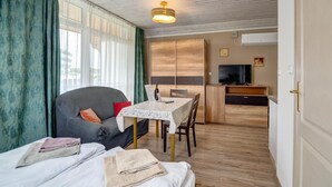 Une pièce comprenant un lit, un canapé, une table à manger et un téléviseur.
