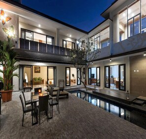 A multi-level outdoor living area with a pool, seating, and a dining area. - Belvilla Elegant Luxury Pandawa Beach (Canggu)