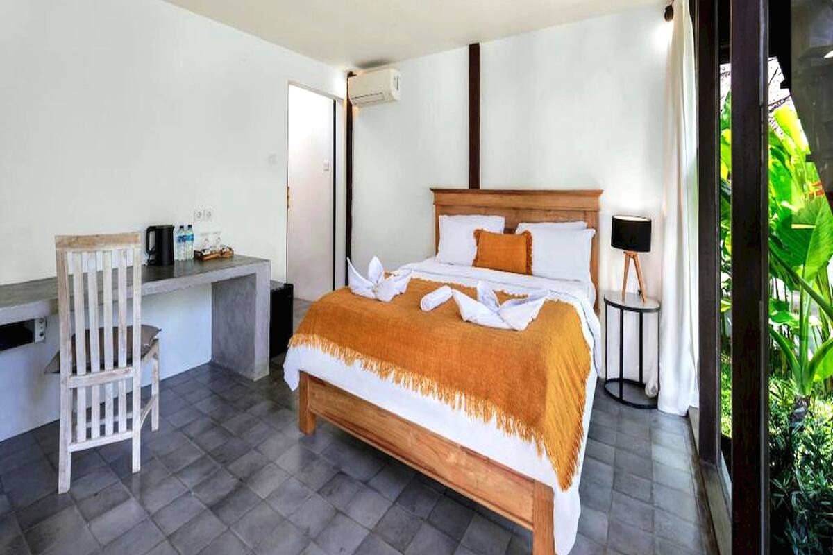 Une chambre d’hôtel moderne, dotée d’un grand lit, d’un bureau et d’une chaise.
