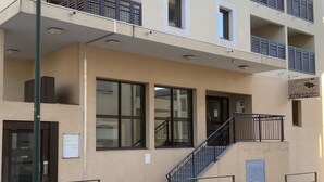 A building with a reception area, a staircase, and a balcony with railings. - Apparemment des Cèdres (Uzès)
