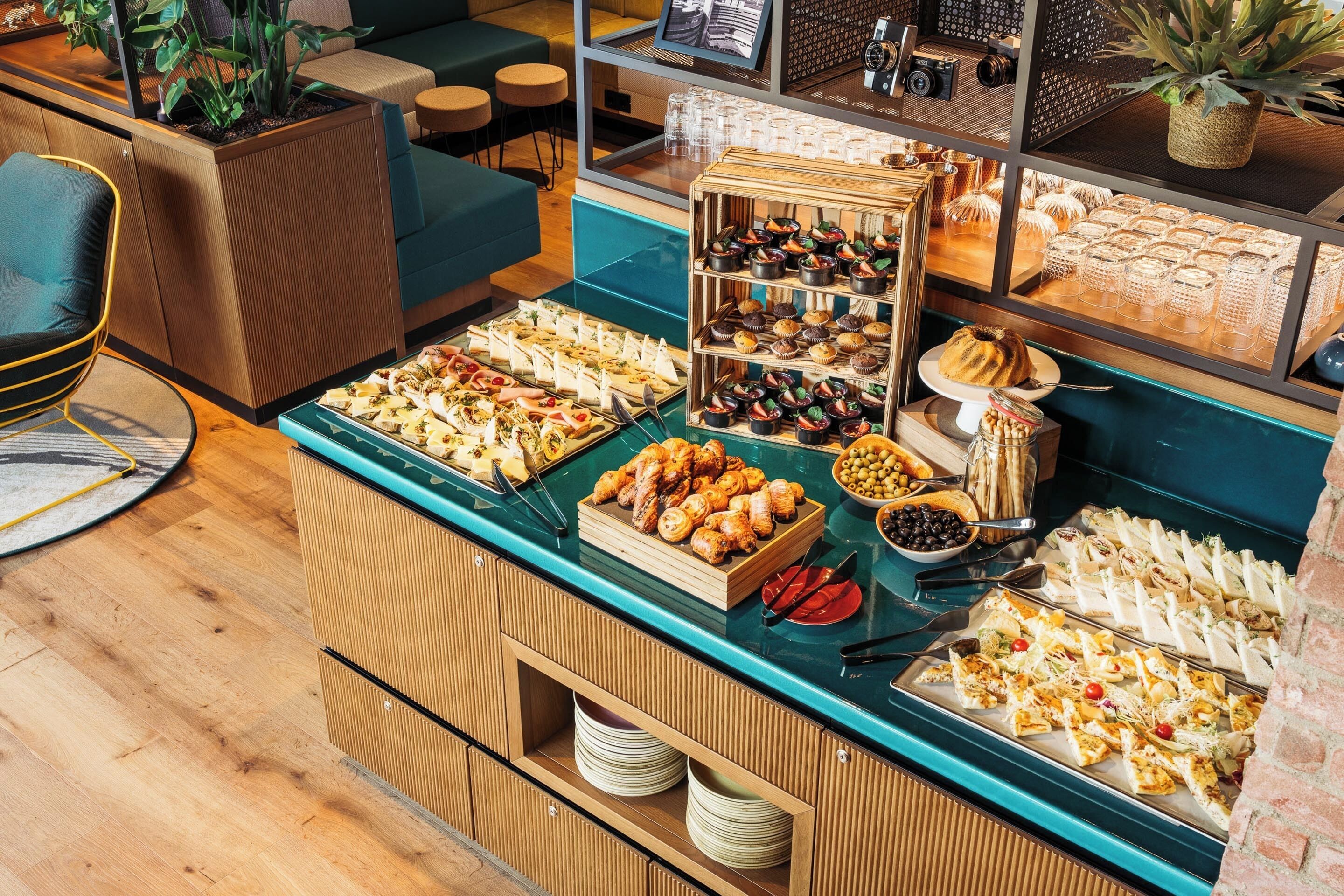 A buffet with various food items and a seating area with chairs and tables.
