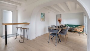 A dining area with a wooden table, grey chairs, and a green sofa. - House for 8, with jacuzzi 200m from the beach (La Bernerie-en-Retz)
