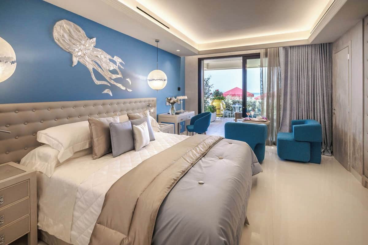 Una habitación de hotel moderna con una cama grande, un escritorio y una zona de estar.