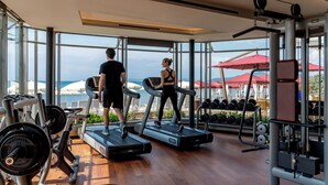 A gym with treadmills, weight machines, and dumbbells. - Cala Beach Resort (Castiglione della Pescaia)