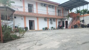 A building with multiple air conditioning units, a covered balcony, and a motorcycle parked outside.