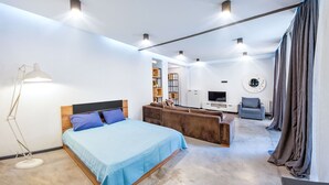 Une chambre moderne avec un lit, un canapé, un bureau et un téléviseur.