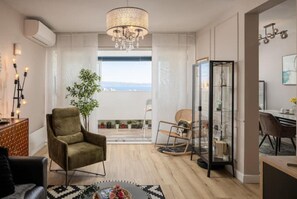 Relax in this inviting living space with a sofa, chair, and chandelier, offering a view of the outdoors.