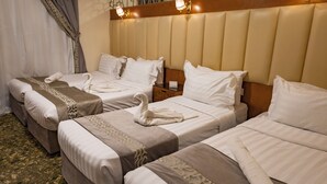 Een hotelkamer met twee bedden, een houten hoofdeinde en een nachtkastje met een lamp.