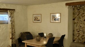 A dining area with a wooden table, black chairs, two framed pictures on the wall, and a window with curtains. - Room in Studio - Enchanting Escapade in Krsuli (Sveti Lovrec)