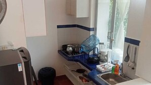 A compact kitchen with a refrigerator, stove, sink, and window. - Casa de Verano Mediterranea (Carmen de Apicalá)