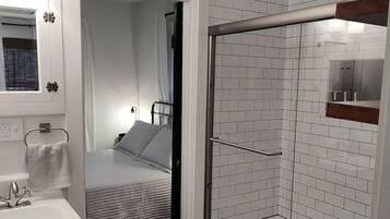 A compact bathroom with a shower, a toilet, and a sink.