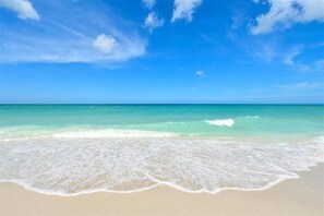 Una spiaggia con acqua cristallina e una battigia sabbiosa.