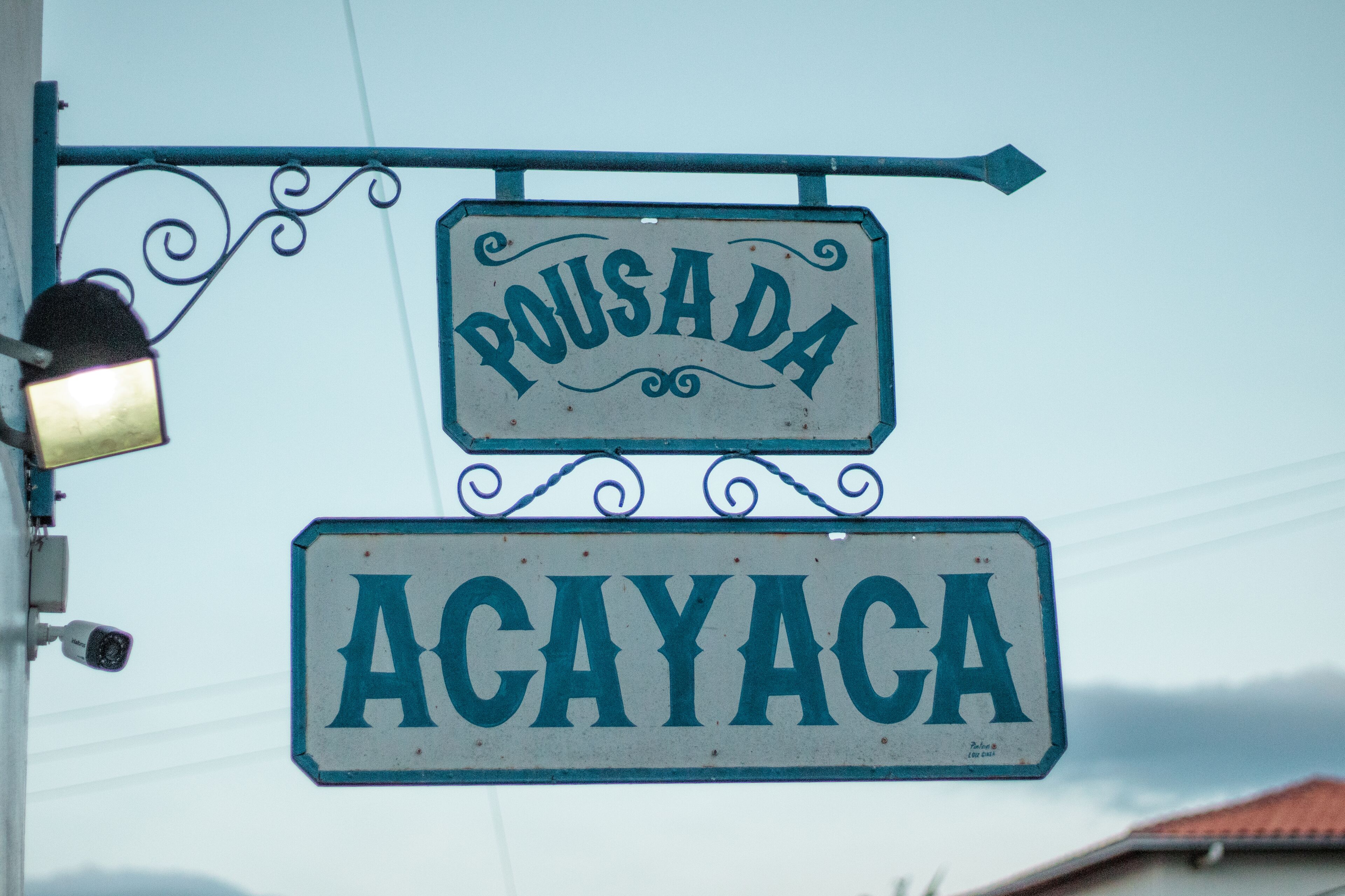 A street sign with "Pousada" and "Acayaca" written on it.