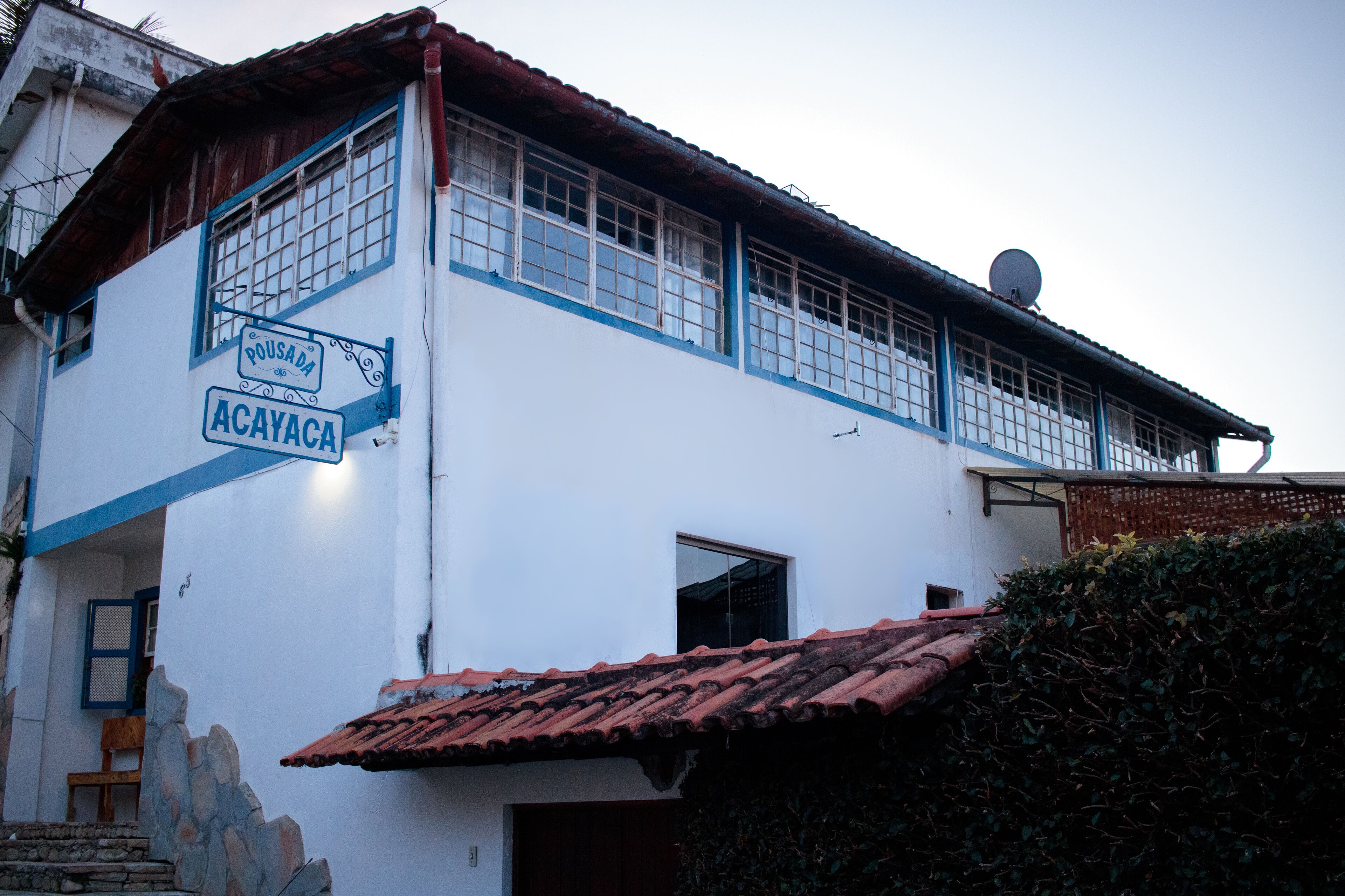 A two-story building with a sign reading "Pousada Acayaca."