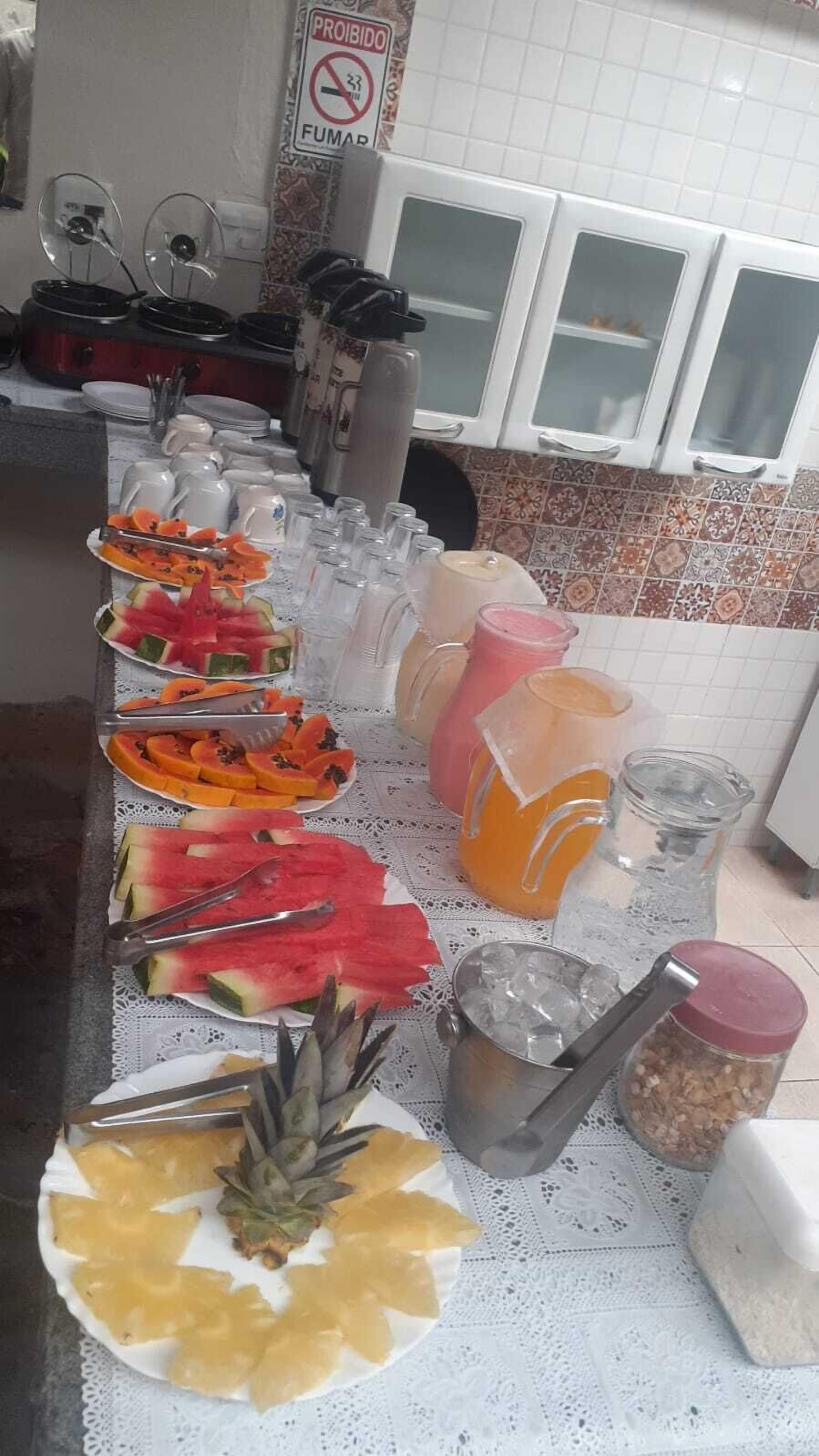 Ett bord med ett urval av olika frukter och drycker, upplagt som en buffé.