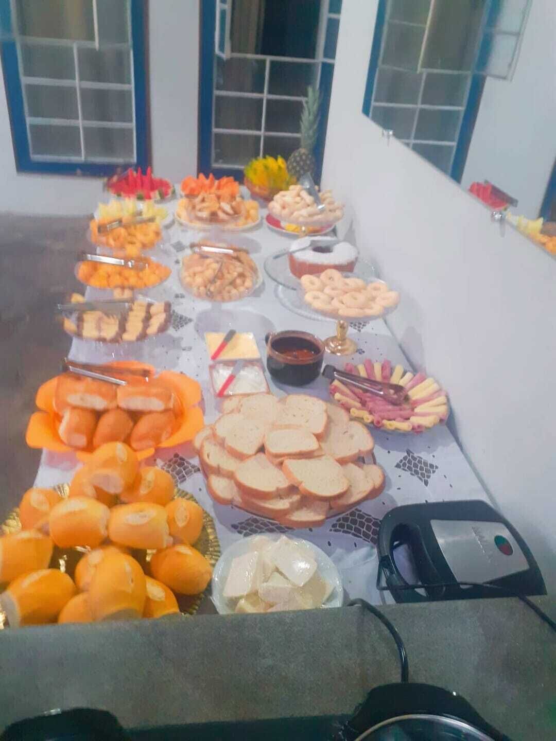 A buffet table with various food items and a small bowl of sauce.