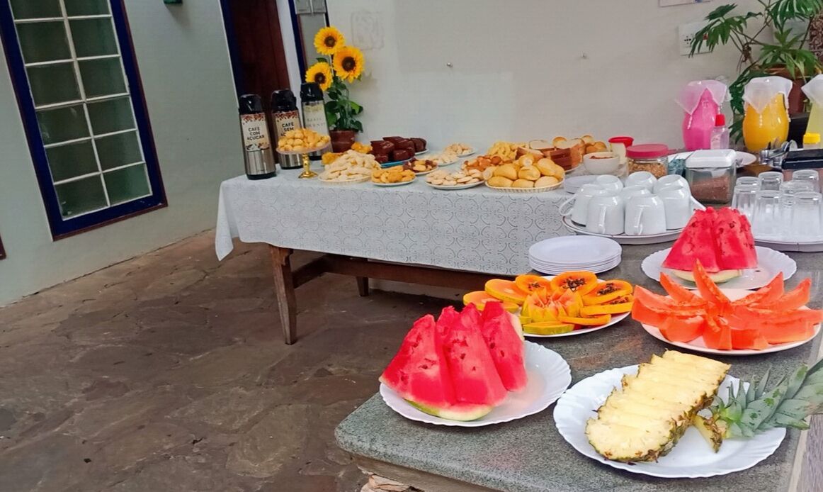 Un bufé de desayuno con diversas frutas, pastelería y bebidas.