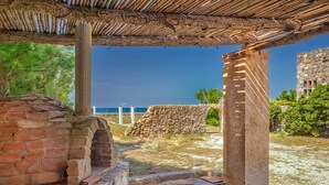 An ancient stone structure with a brick wall and a thatched roof. - Platanias Beachfront Villa Elsa-90m to main Square (GW95+FMM Platanias, Greece)