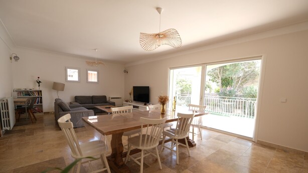 A spacious living area with a dining table, chairs, a sofa, and a TV. There is a balcony with a railing and a view of greenery. - Vacation rental house with pool MOURIES LS1-434 (Mouriès)