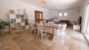 A spacious living area with a dining table, chairs, and a sofa. There is a bookshelf, a potted plant, and a television. - Vacation rental house with pool MOURIES LS1-434 (Mouriès)