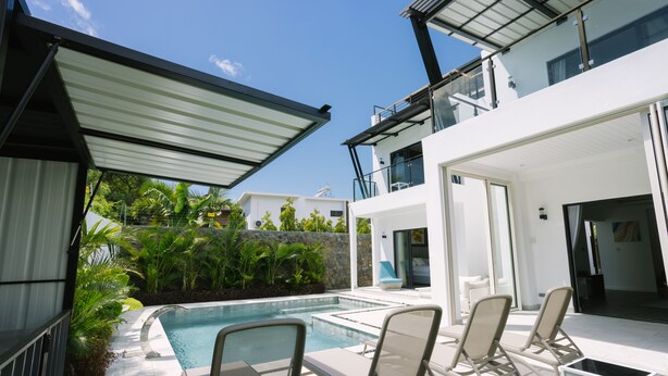 A modern outdoor pool area with lounge chairs and a covered patio. - Pearl Villa (Grand-Baie)