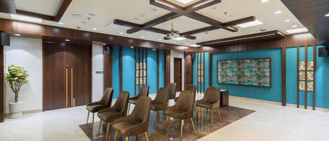 A spacious lobby with a high ceiling, recessed lighting, and a large abstract painting on the wall.