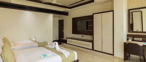 A hotel room with a large bed, a desk, a television, and a wardrobe.