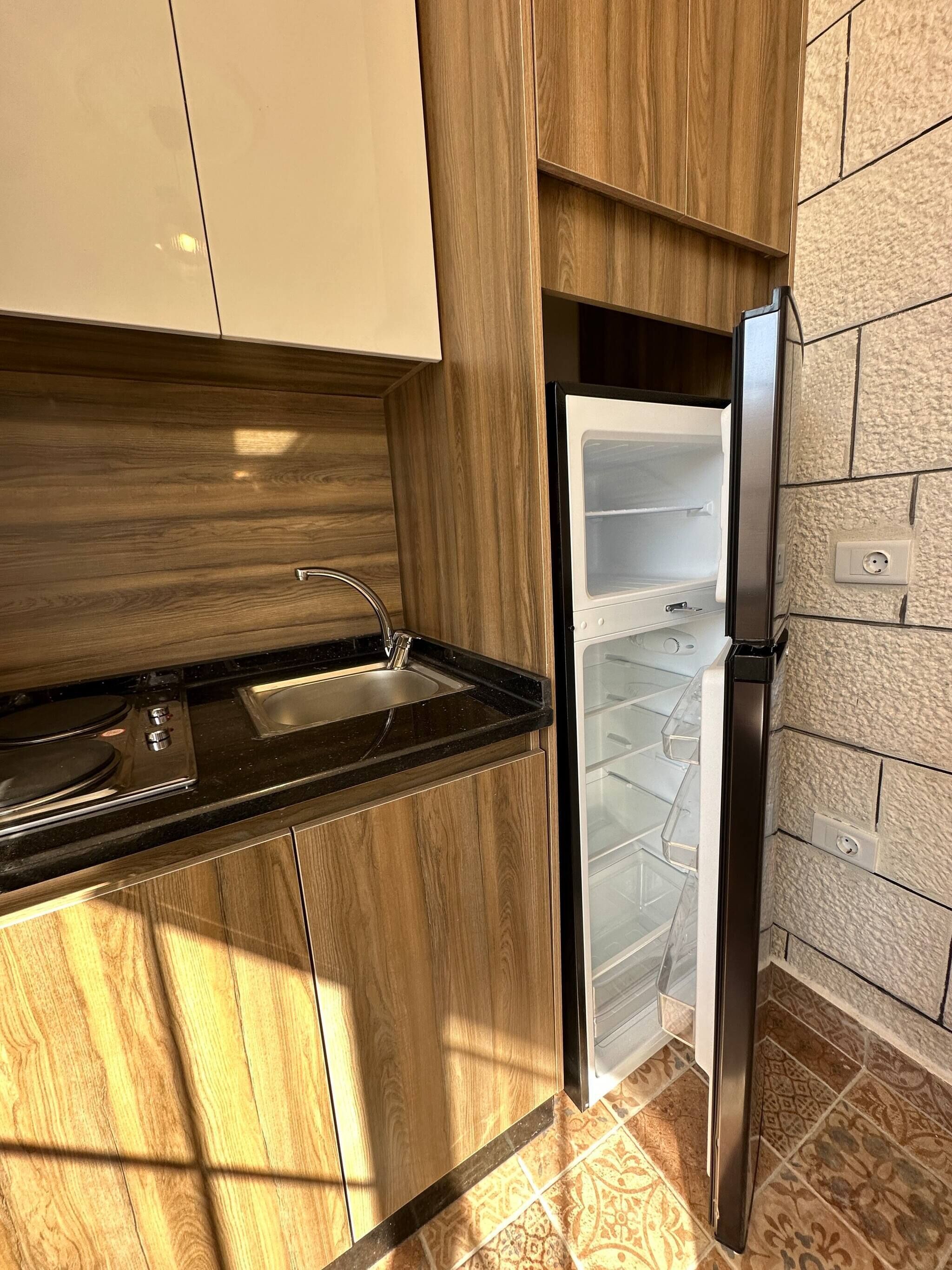 A kitchen with a built-in stove, a sink, and a refrigerator.