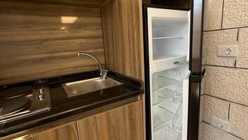 A kitchen with a built-in stove, a sink, and a refrigerator.