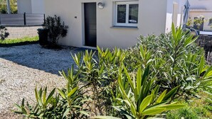 Una casa a un piano con tetto in tegole, una porta d'ingresso e una piccola finestra.