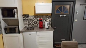Une cuisine compacte équipée d’un four à micro-ondes, d’un grille-pain et d’un petit réfrigérateur.